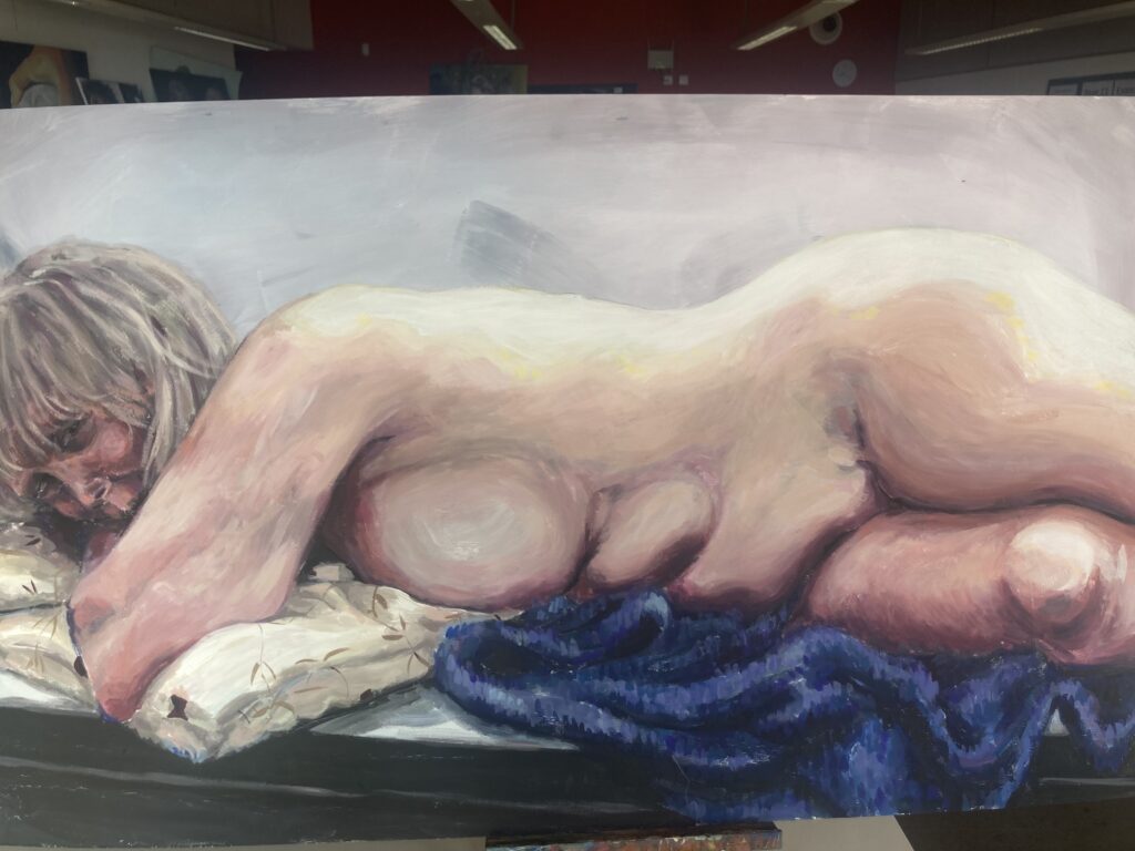 A nude woman reclining on a bed she is peering at the viewer 