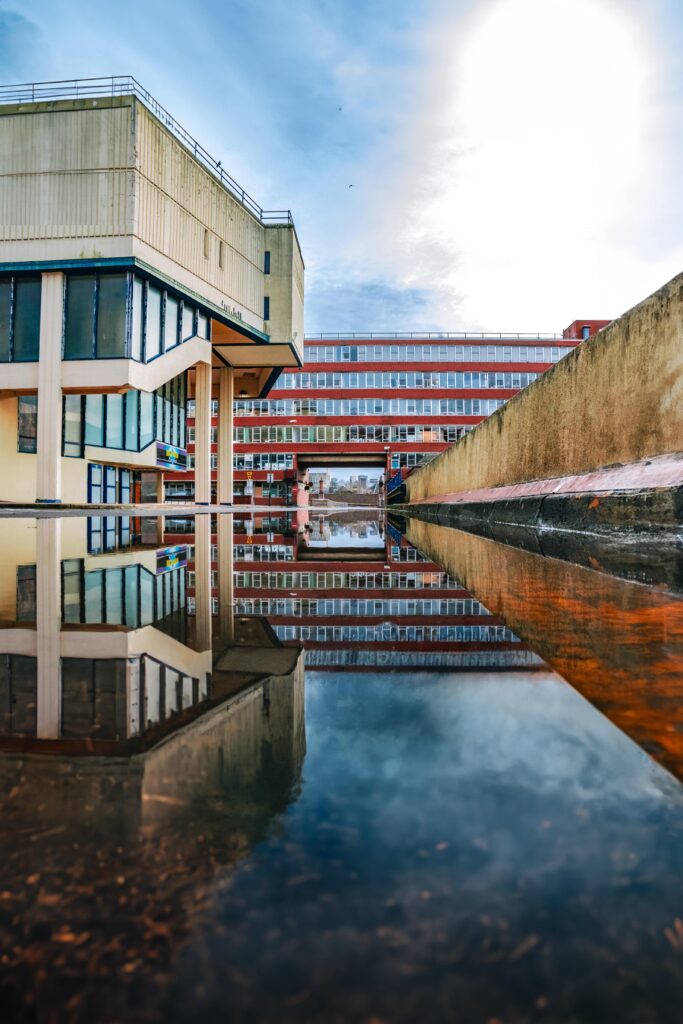 Urban buildings reflecting in a large puddle