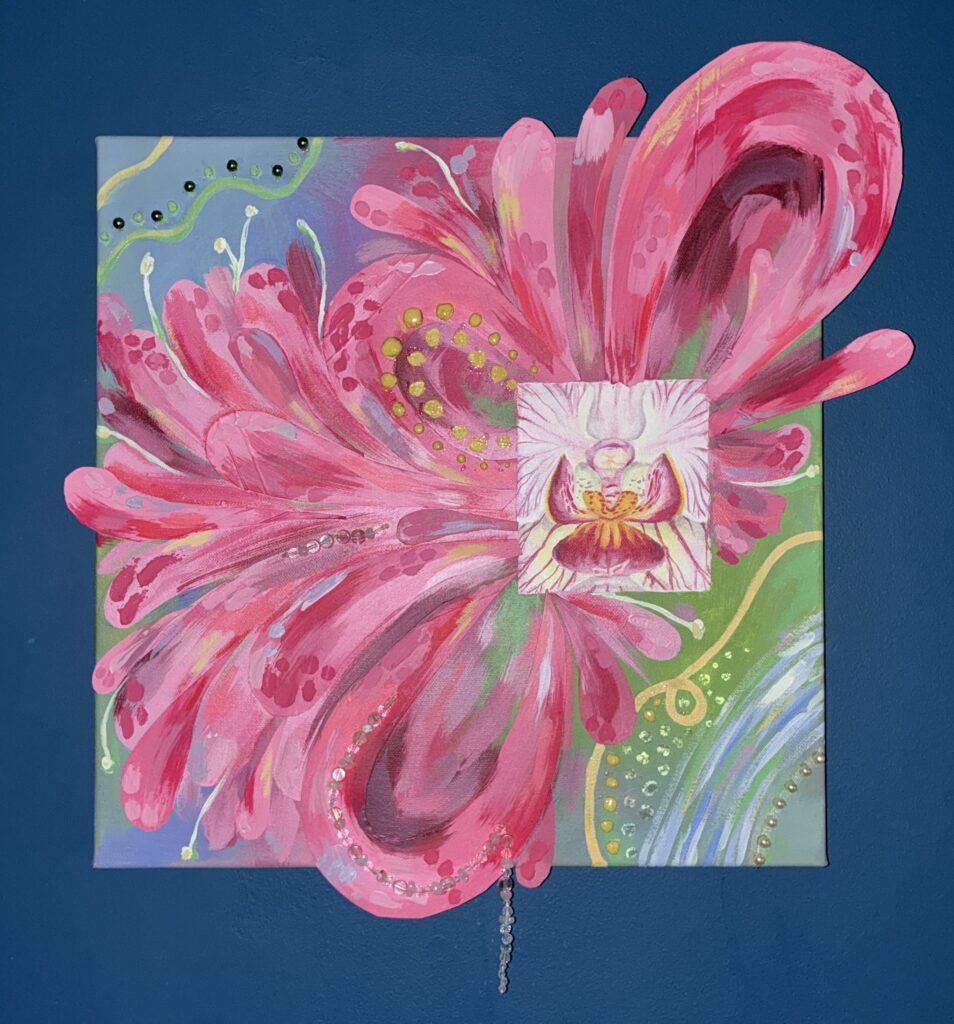 A mixed media painting of a pink flower layered over a bright, patterned background.
